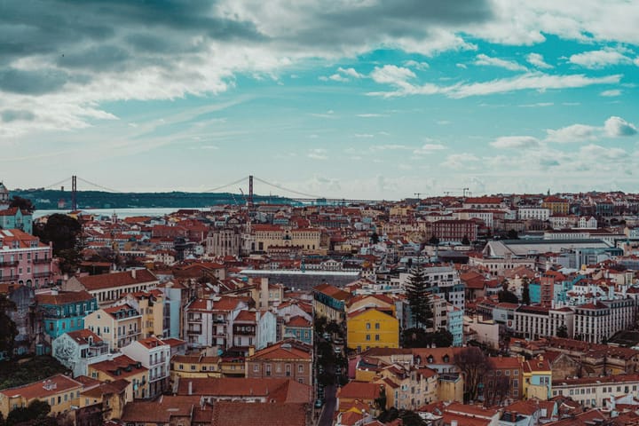 Lisbon rooftops with the 25 de Abril bridge across the Tagus in the distance