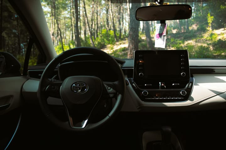 Driver's view of a car steering wheel and dashboard — illustrative of driving in Portugal under an exchanged licence.
