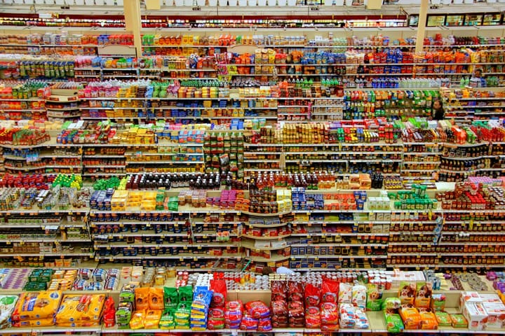 Fully stocked supermarket shelves filled with colourful packaged grocery products