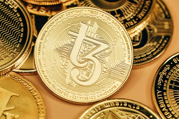 A pile of gold cryptocurrency coins including bitcoin-style tokens