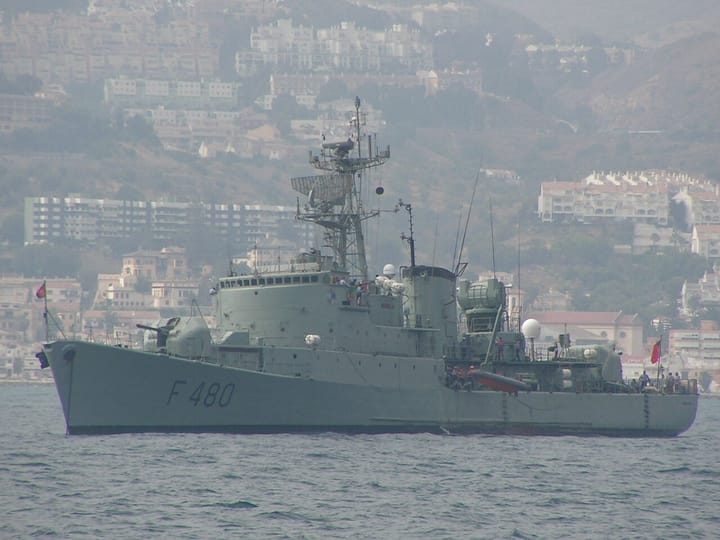 A Portuguese Navy frigate under way at sea near a coastline
