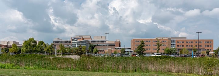 The exterior of a large modern hospital complex of brick and glass buildings