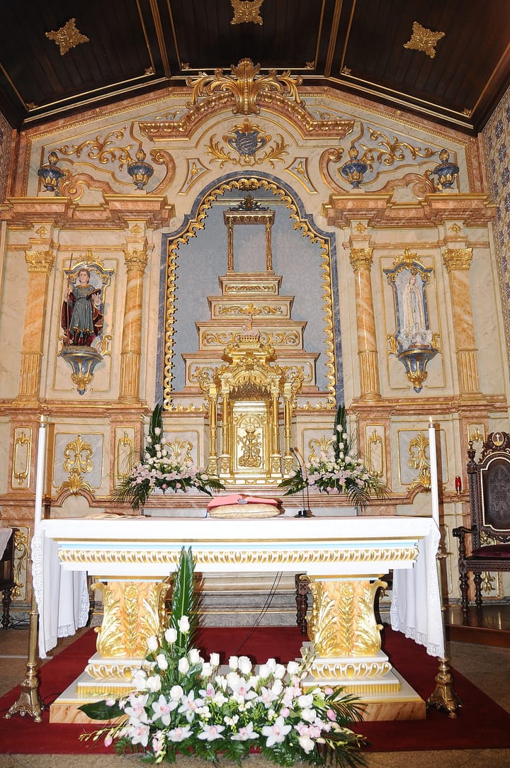The ornate gilded altar of the Sao Mamede church in Lisbon decorated with white flowers