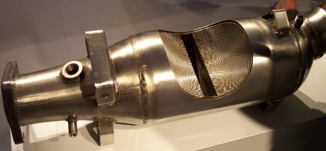 A cut-open car catalytic converter on display, revealing the honeycomb ceramic core coated with the platinum-group metals that thieves target