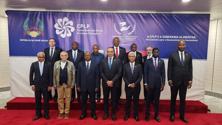 Heads of state and government of the Community of Portuguese Language Countries pose for a group photograph on a red carpet in front of a CPLP summit banner