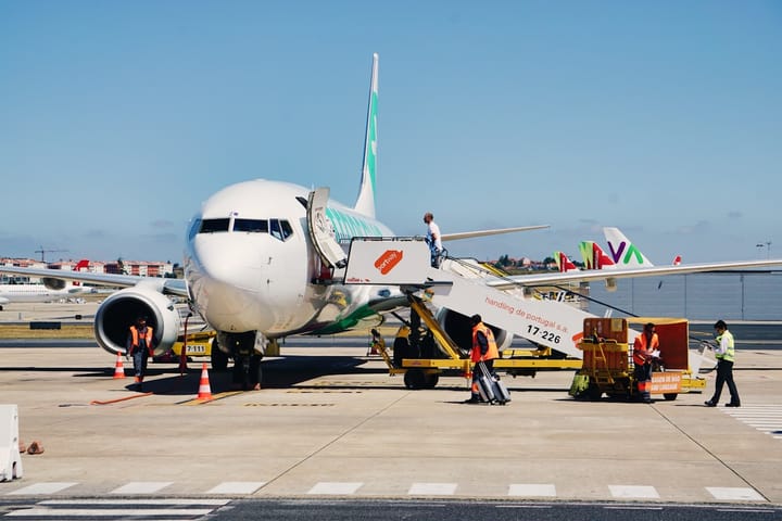 A Transavia aircraft boarding at Lisbon Airport with Portuguese ground crew