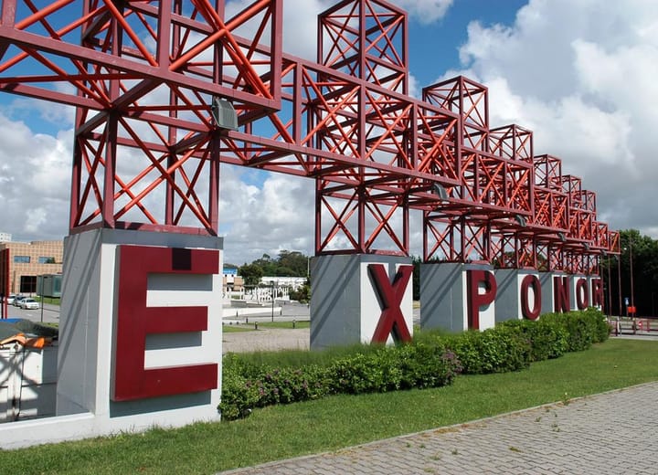 The large red steel EXPONOR sign at the entrance to the Exponor exhibition complex in Matosinhos under a blue sky