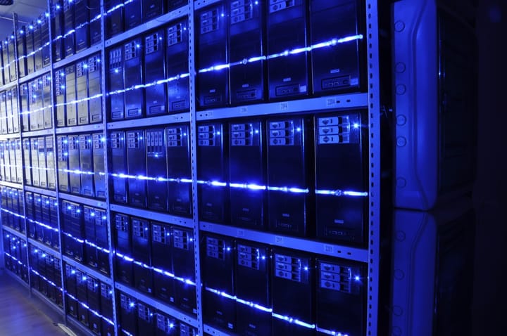 Rows of servers glowing with blue indicator lights inside a data centre