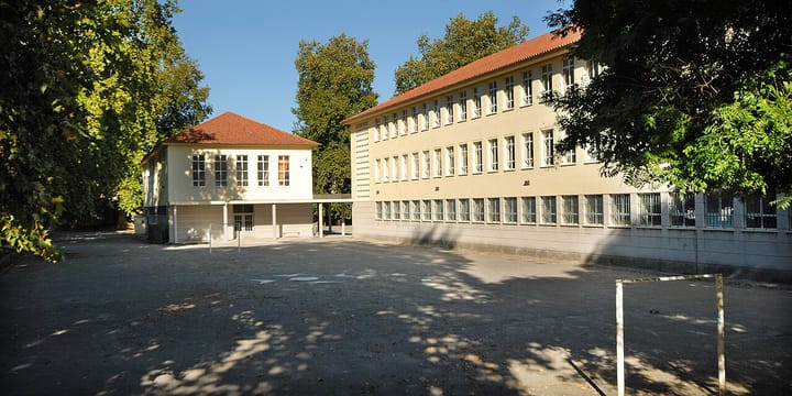 The empty schoolyard and buildings of a Portuguese state school in Porto, with a football goalpost, before the start of the new term