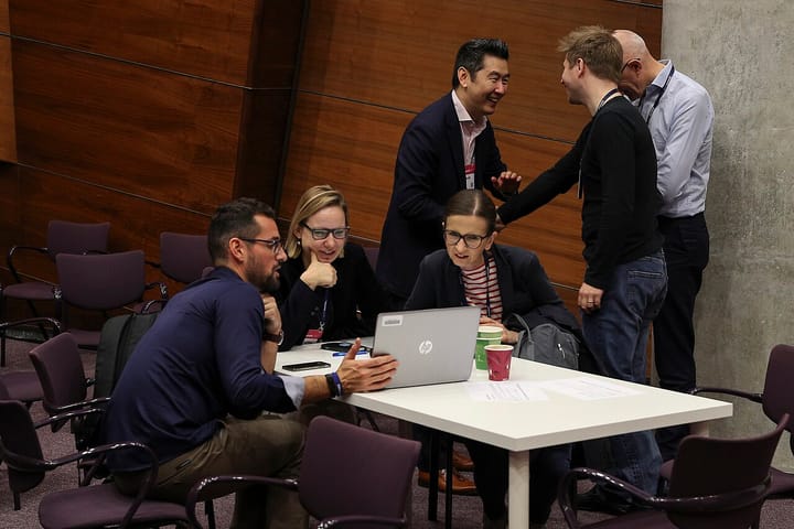Business people gathered around a laptop at a technology workshop during the Web Summit in Lisbon