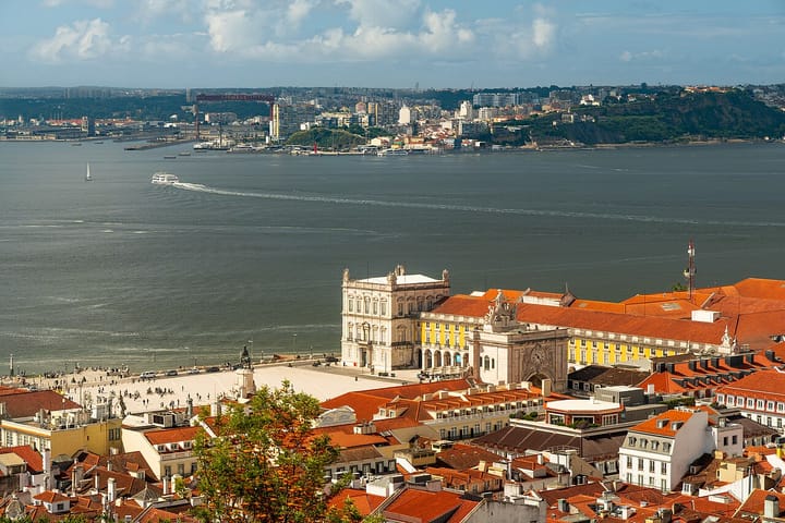 An aerial view of Lisbon's riverside Praça do Comércio, its yellow arcaded buildings and grand square beside the Tagus, Portugal's historic commercial heart