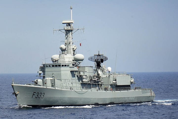 The Portuguese Navy frigate NRP Bartolomeu Dias, pennant number F333, under way at sea under a clear blue sky
