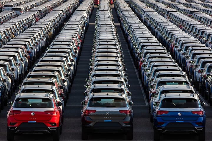 Rows of brand new Volkswagen T-Roc cars in red, grey, blue and white, photographed from above, parked bumper to bumper on the quayside at the port of Setubal in Portugal