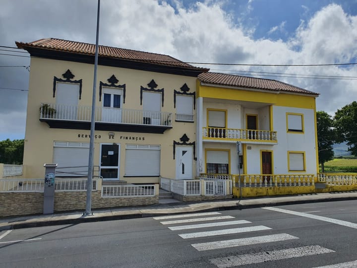 A Portuguese Servico de Financas tax office in Praia da Vitoria in the Azores, its name lettered across a cream two-storey building beside the road