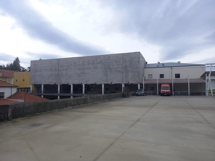 The exterior of the emergency department (Urgências) building at the Hospital da Guarda in Portugal under a cloudy grey sky