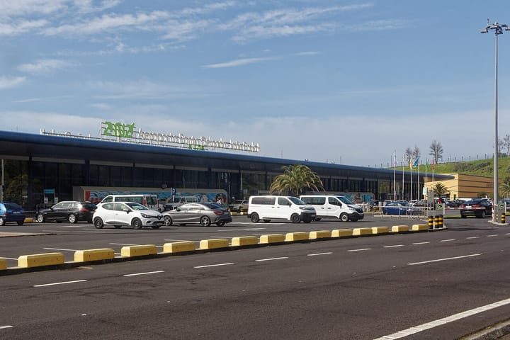 The terminal frontage of Ponta Delgada airport in the Azores, with the ANA sign reading Aeroporto Ponta Delgada Joao Paulo II above the glass front and cars in the forecourt.