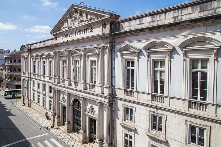 The stone facade of the Tribunal da Relacao de Coimbra, its pediment carrying the inscription Domus Iustitiae