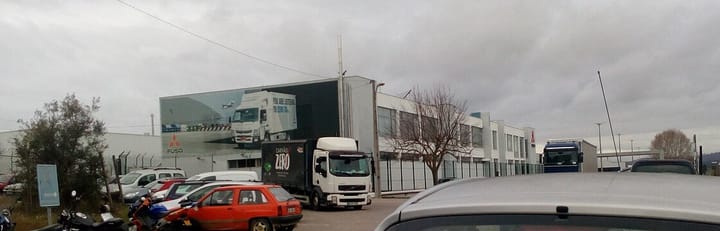 The Mitsubishi Fuso truck plant at Tramagal in Abrantes, Portugal, with the FUSO logo on its frontage and lorries parked in the yard