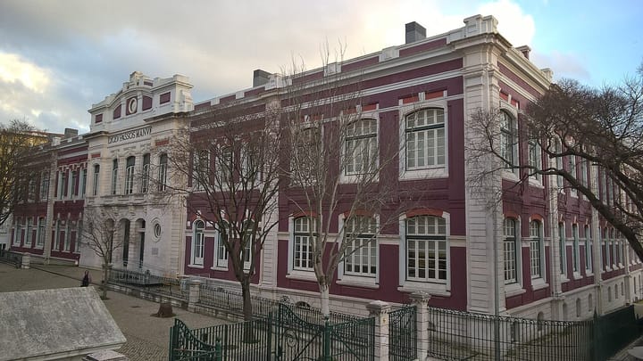 The dark red and white facade of the Liceu Passos Manuel secondary school in Lisbon, Portugal