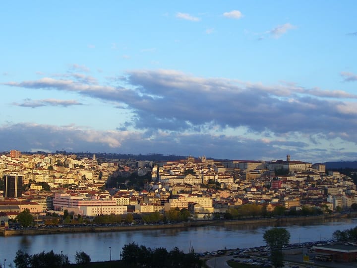 The city of Coimbra rising above the Mondego river in central Portugal at dusk