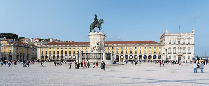 The Praca do Comercio in Lisbon at ground level, with the equestrian statue of King Jose I in the centre and the yellow arcaded wings housing government ministries on either side.