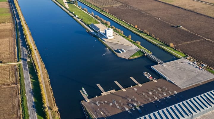 Aerial view of the Montemor-o-Velho nautical centre in Portugal, showing the flatwater regatta course, the finish tower and racks of racing kayaks beside the Mondego lowlands