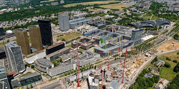 Aerial view of the Kirchberg European quarter in Luxembourg, with the gold towers of the Court of Justice of the European Union on the left and cranes in the foreground