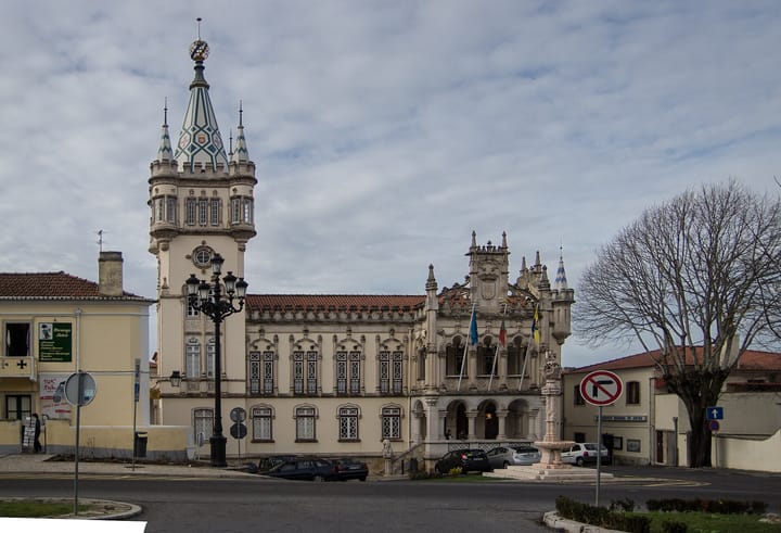 The Paços do Concelho in Sintra, a late nineteenth century town hall with a tiled spire and the Portuguese flag flying from the balcony.