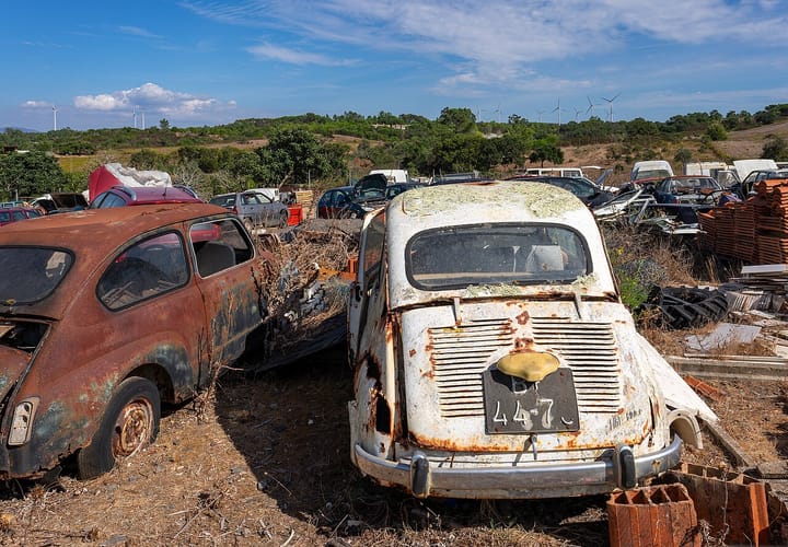 Rusting old cars, one with a Portuguese number plate, in a scrapyard near Monte dos Cairos in the southwest of Portugal