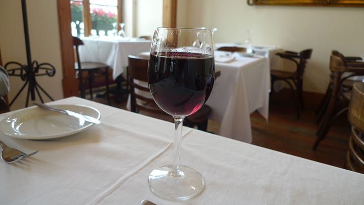 A glass of red wine on a white tablecloth in a Lisbon restaurant