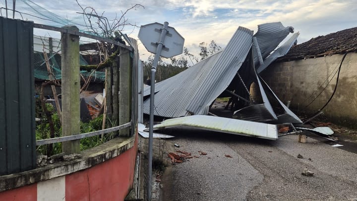 Sheets of metal roofing torn off by Storm Kristin lying across a village street in Amor, Leiria