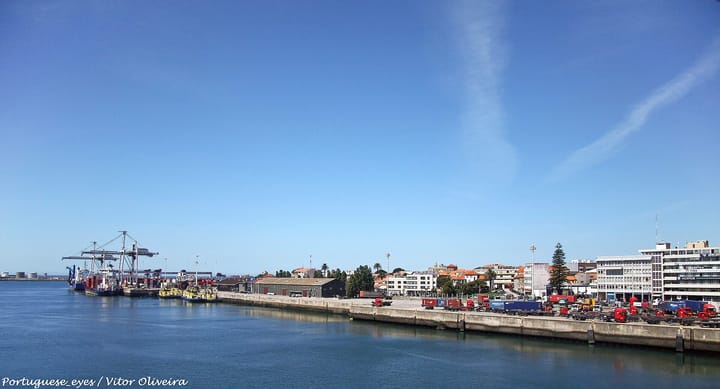 The Port of Leixoes at Matosinhos in Portugal, with gantry cranes and a container ship at the far quay and rows of shipping containers on wagons along the near wharf