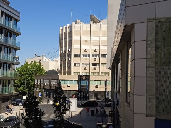 The Embassy of the Russian Federation in Lisbon, a stone-clad building with satellite dishes on the roof and the Russian coat of arms above the entrance