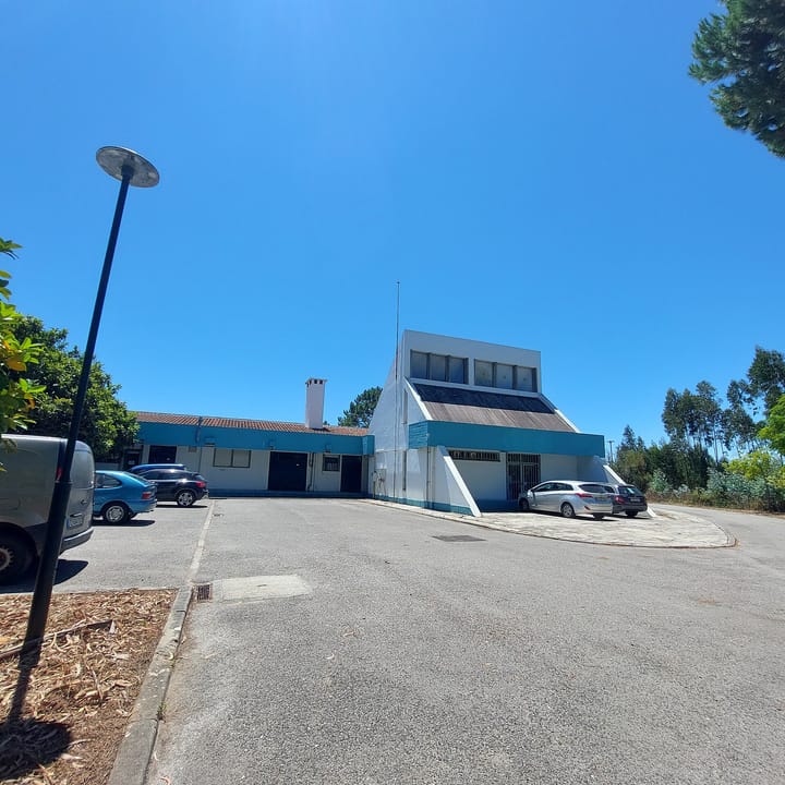 A Portuguese public health centre in Rio Maior, Santarem district, a low white and blue-trimmed building with a pitched glazed section and cars parked outside