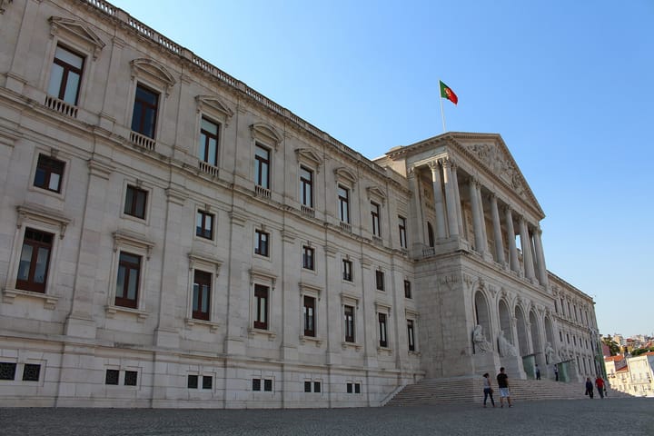 The Palacio de Sao Bento in Lisbon, seat of the Assembleia da Republica, its colonnaded portico and long stone facade with the Portuguese flag flying above