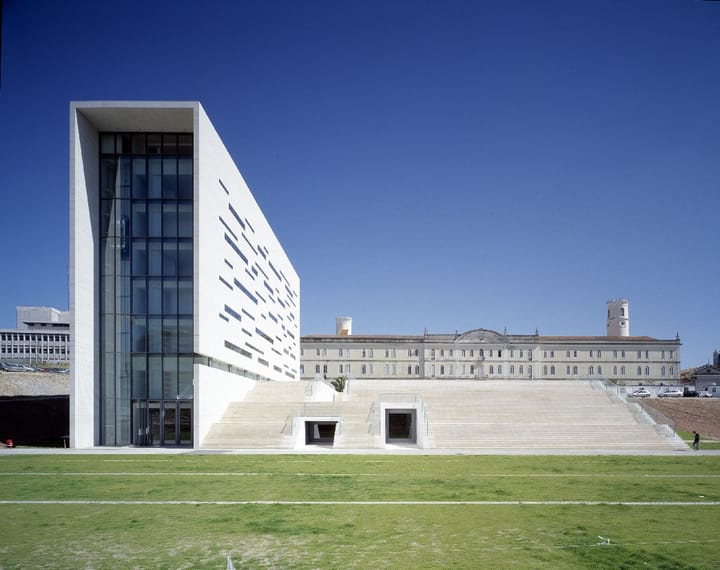 The white modern rectorate building of the Universidade Nova de Lisboa at Campolide, with wide stone steps and a long historic building behind
