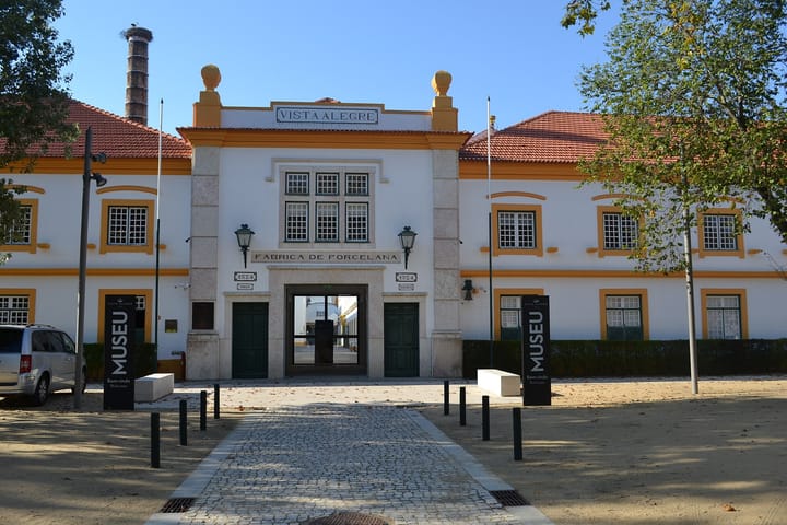 The entrance to the Vista Alegre porcelain factory at Ilhavo, a white and yellow two-storey building with the words Vista Alegre and Fabrica de Porcelana carved above the archway
