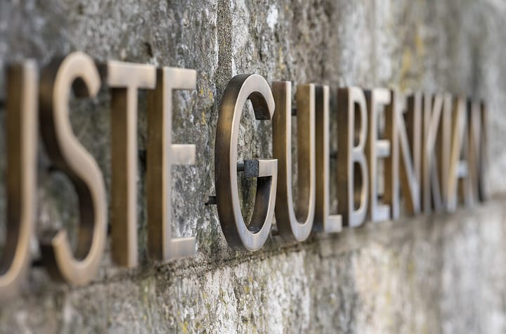 Bronze letters spelling Calouste Gulbenkian on a stone wall at the foundation's headquarters in Lisbon